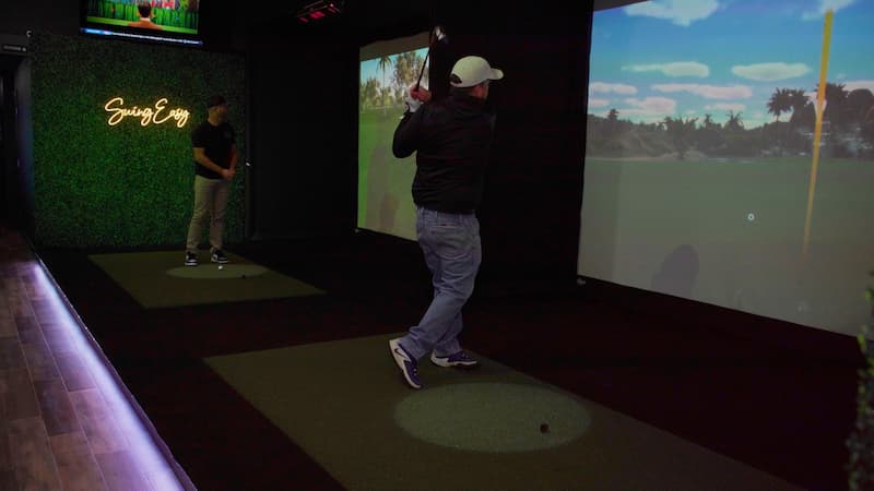 Slice Golf indoor golf facility where man is golfing in backswing